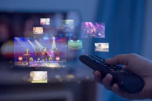 Close-up,Of,Hands,Using,Remote,Smart,Tv,On,Blurred,Smart
